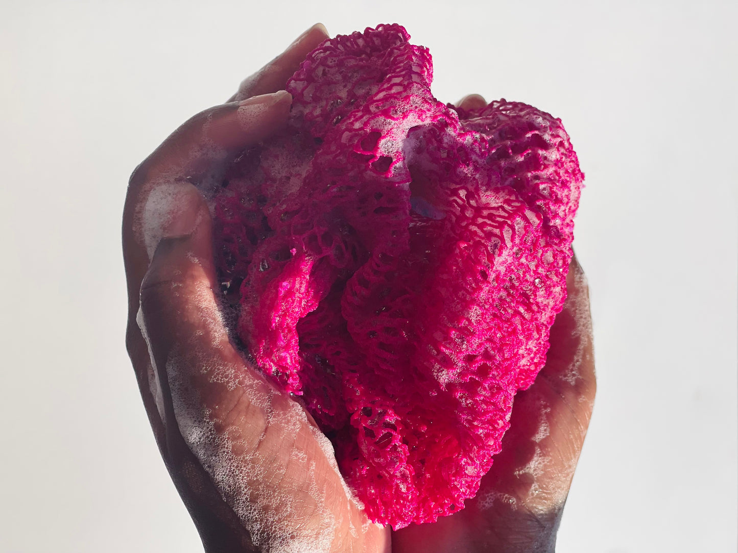 hands holding an African bath sponge